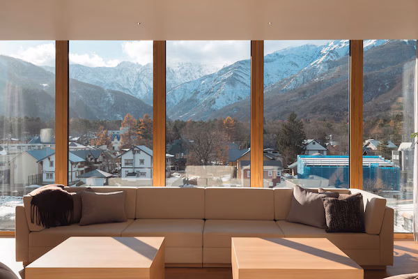 A modern living room with a large window offering a mountain view.
