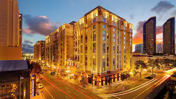 A multi-story hotel with a modern architectural design, featuring a prominent entrance and a well-lit street view.