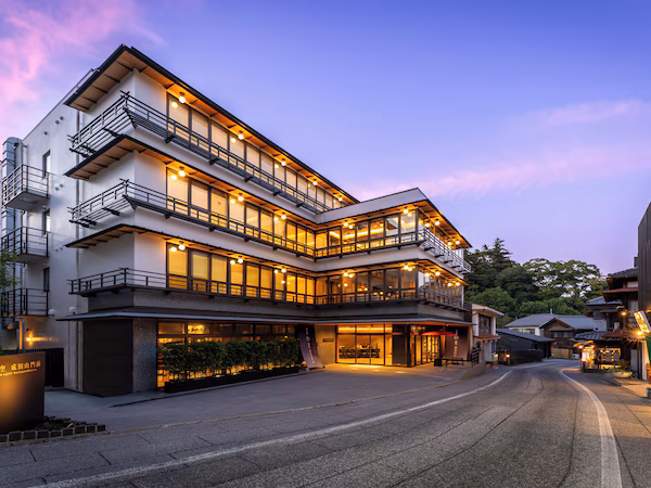A multi-story hotel with a modern architectural design, featuring balconies and large windows.